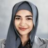A woman wearing a grey hijab and grey blazer smiles softly at the camera. The softly blurred background keeps the focus on her face, reflecting confidence—perfect for adults seeking ADHD support in Ontario.